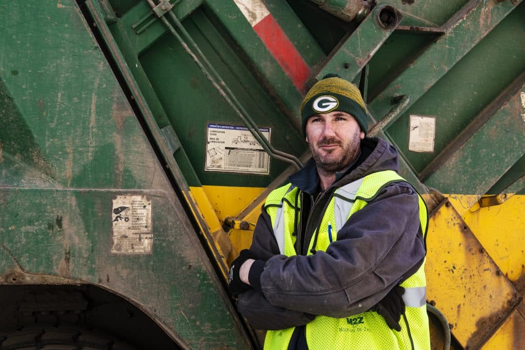 Waste Management driver assistant Thomas McCarten leans against a truck on Thursday, March 26, 2020. McCarten has worked for Waste Management for three and a half years and is considered an essential employee. 