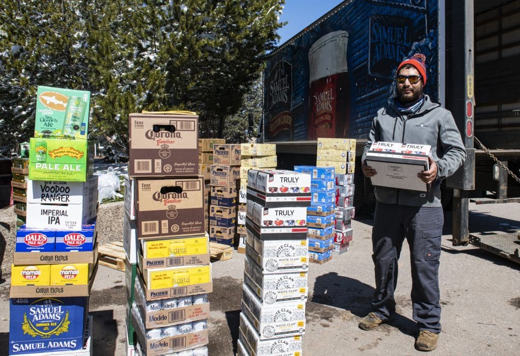 Axel Chavez, a beer delivery driver, unloads a shipment of alcohol to Aspen on Thursday, April 2, 2020. “We lost so much business with the bars and restaurants, so we’re trying to keep on going as long as we can,
