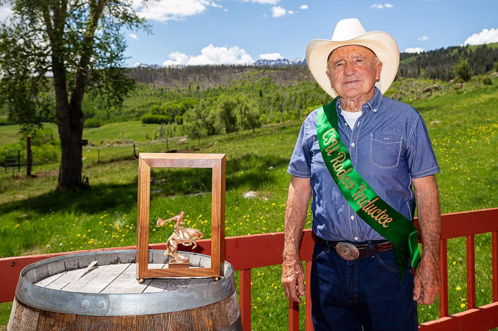 Standing with one of his trophies and championship belt buckle, Rodeo Hall of Fame inductee George Culbreath is photographed at his Heeney ranch on May 30.
