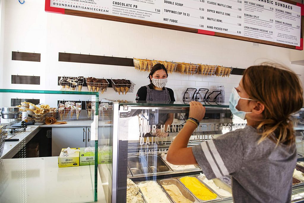 Sundae’s Annika Bucchin, 17, helps a young customer with a waffle cone selection at the artisan ice cream shop in Snowmass Base Village on Thursday, July 30, 2020. 