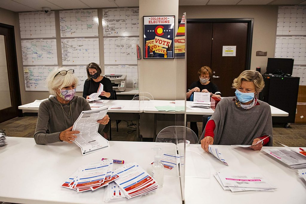 Carolyn Fieles, left, Suzy Meredith-Orr, Frieda Wallison, and Judy Dunn open ballots in the Pitkin County Administration Building on Election Day in Aspen on Tuesday, Nov. 3, 2020. The volunteers were checking that the ballots weren’t stained and that they were labeled as Pitkin County ballots. (Kelsey Brunner/The Aspen Times)