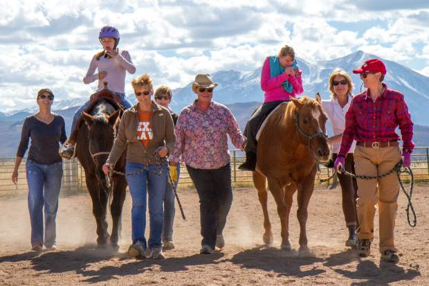 Multple volunteers work with clients Gwen Carew and Amanda VanDeursen during their sessions with the horses.