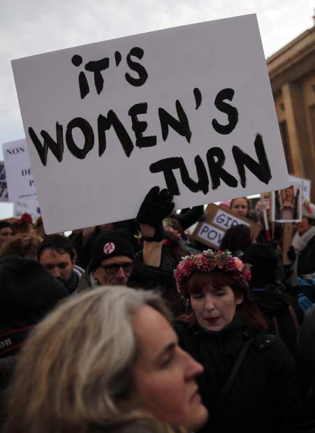 Protesters carrying banners and placards take part in a Women's March next to the Eiffel Tower, in Paris, France, Saturday, Jan. 21, 2017. The march is part of a worldwide day of actions following the inauguration of U.S President Donald Trump. (AP Photo/Christophe Ena)