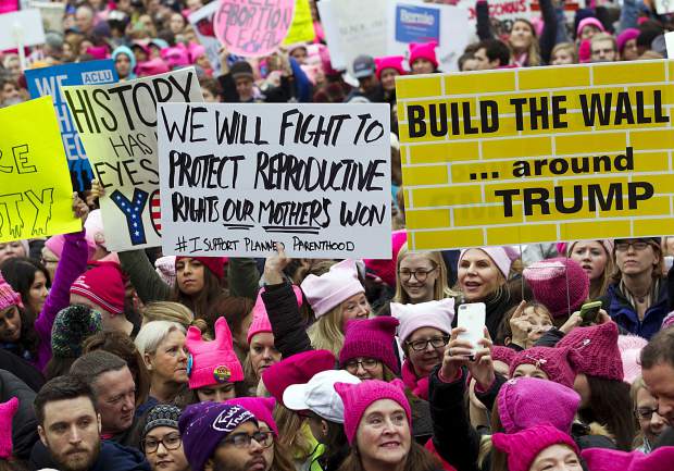Women with bright pink hats and signs begin to gather early and are set to make their voices heard on the first full day of Donald Trump's presidency, Saturday, Jan. 21, 2017 in Washington. Organizers of the Women's March on Washington expect more than 200,000 people to attend the gathering. Other protests are expected in other U.S. cities. ( AP Photo/Jose Luis Magana)
