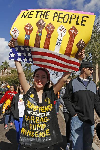 A demonstrator holds a sign as she marches in support of the Women's March on Washington Saturday, Jan. 21, 2017, in Phoenix. Thousands of protesters in Phoenix joined in support of those in cities around the globe protesting against Donald Trump as the new United States president.