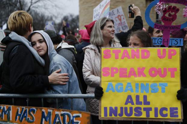 Protestors wait for speakers to begin their speeches in the cold along the barricades at the Women's March on Washington during the first full day of Donald Trump's presidency, Saturday, Jan. 21, 2017 in Washington. Organizers of the Women's March on Washington expect more than 200,000 people to attend the gathering. Other protests are expected in other U.S. cities.