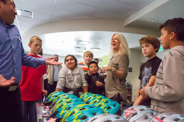 Sonja Linman, a prevention specialist at Glenwood Springs Middle School, and Alpine Bank employee Carlos Jaquez explain to students how they will be receiving their new bike helmets provided by Alpine Bank.