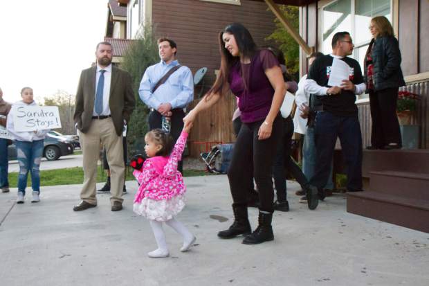 Sandra Lopez and her 2-year-old daughter Areli walk outside of the Parsonage in which Sandra will be taking sanctuary in Carbondale.