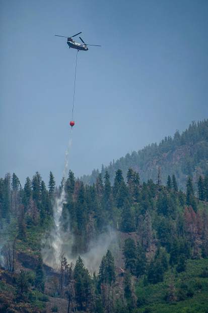 A Chinook helicopter drops a bucket of water on Basalt Mountain from Cedar Drive on Sunday afternoon.