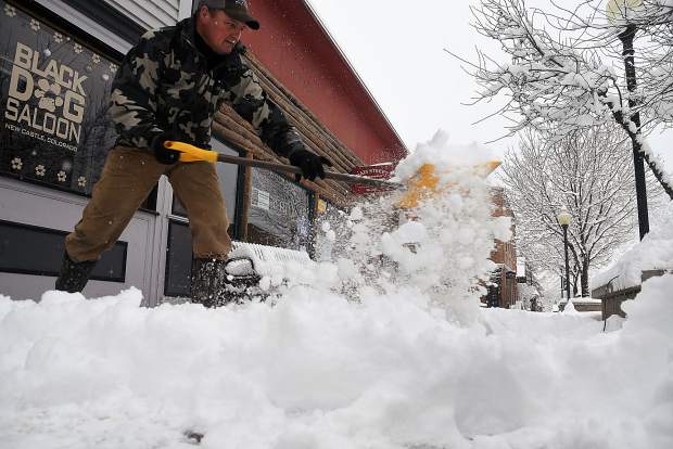 Snow flies as Roger Grove of New Castle clears off around five inches of fresh snow from the sidewalk in front of his resturant Monday.