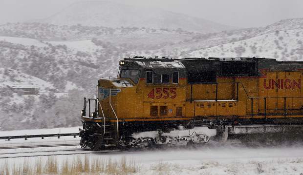 A Union Pacific freight train kicks up snow as it barrels down the tracks along Interstate 70 west of Glenwood Springs a few years ago.