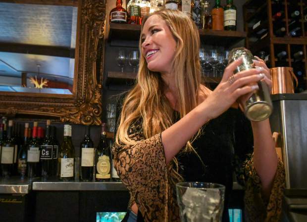 Andrea Noeli Eason mixes up a cocktail for a customer at the bar at Colorado Ranch House where she has been a server for roughly two years.