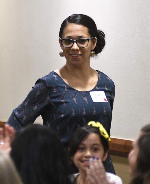 A surprised Claudia Flores Cruz stands up to accept her 2019 Garfield County Humanitarian Service Award Monday at Grand River Health in Rifle.