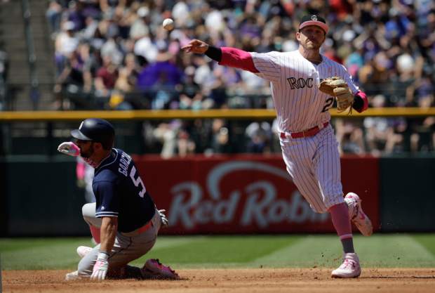 Colorado Rockies third baseman Ryan McMahon, right, forces out San Diego Padres baserunner Greg Garcia, left, at second base in the third inning of a baseball game in Denver, Sunday, May 12, 2019.(AP Photo/Joe Mahoney)