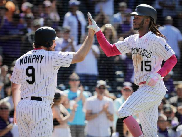 Colorado Rockies' Daniel Murphy (9) congratulates teammate Raimel Tapia (15) after Tapia hit a home run that also scored him in the seventh inning of a baseball game against the San Diego Padres in Denver, Sunday, May 12, 2019. (AP Photo/Joe Mahoney)