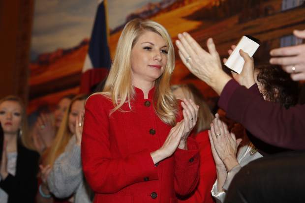 FILE - In this April 12, 2019, file photo, Colorado State Sen. Brittany Pettersen, D-Lakewood, applauds after speaking at a bill signing that allowed Colorado to become the 15th state to adopt a 
