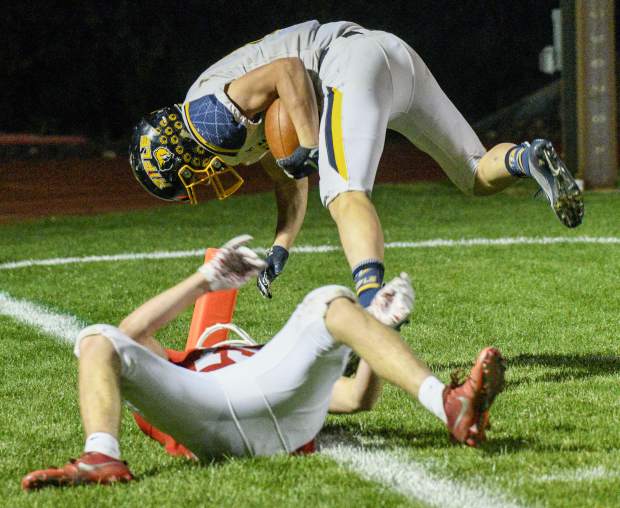 Rifle’s Levi Warfel flips over Glenwood’s Blake Nieslanik for the touchdown late in the second quarter. Warfel scampered 85 yards on the play to give the Bears 20-7 lead.