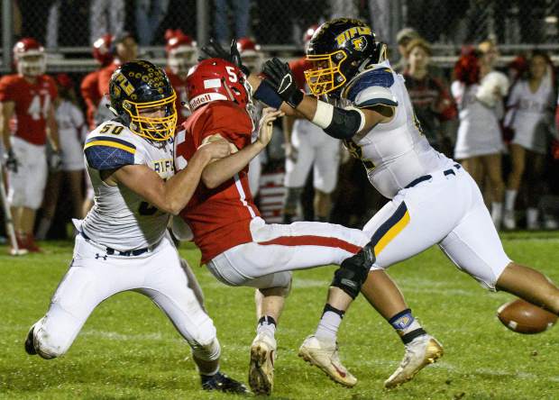 Glenwood’s Even Heyl looses the ball as Rifle’s Etahn Mackley and Ariel Herrera bring him down in the third quarter. The officials ruled that Heyl threw the ball, and the Demons were penalized for intentional grounding.