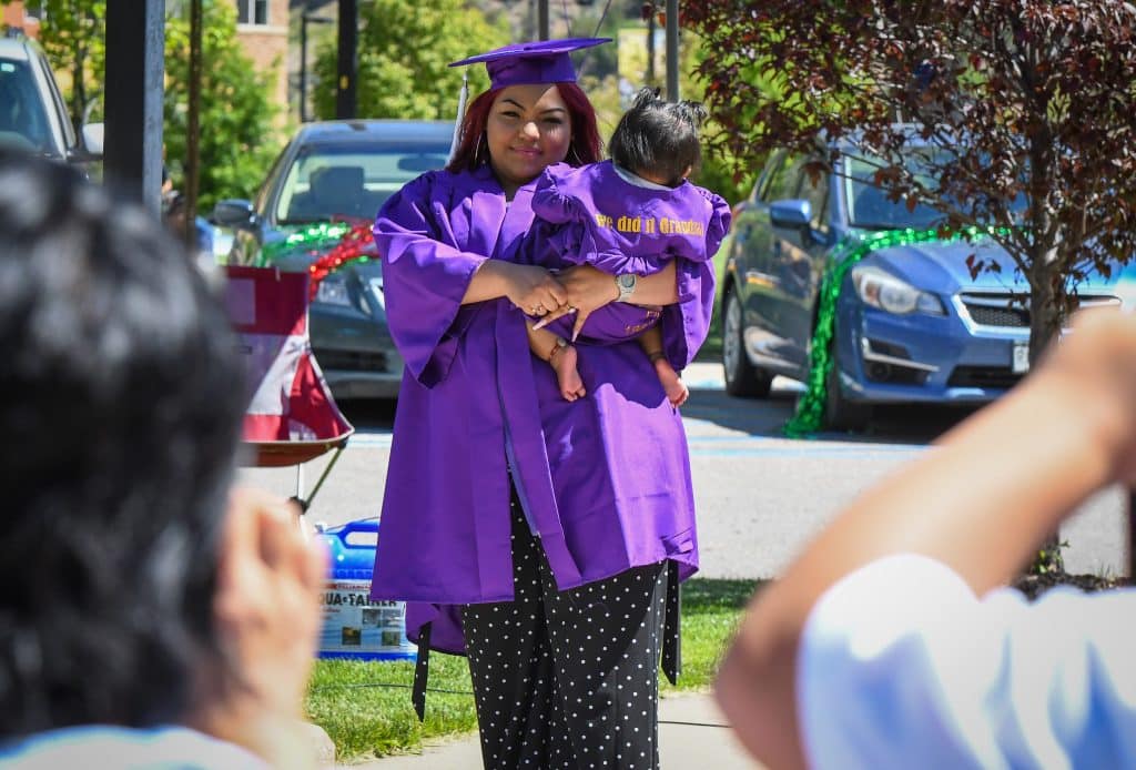 A Yampah Mountain High School graduate looks to her family before recieving her diploma at the drive-in graduation ceremony on Friday morning.