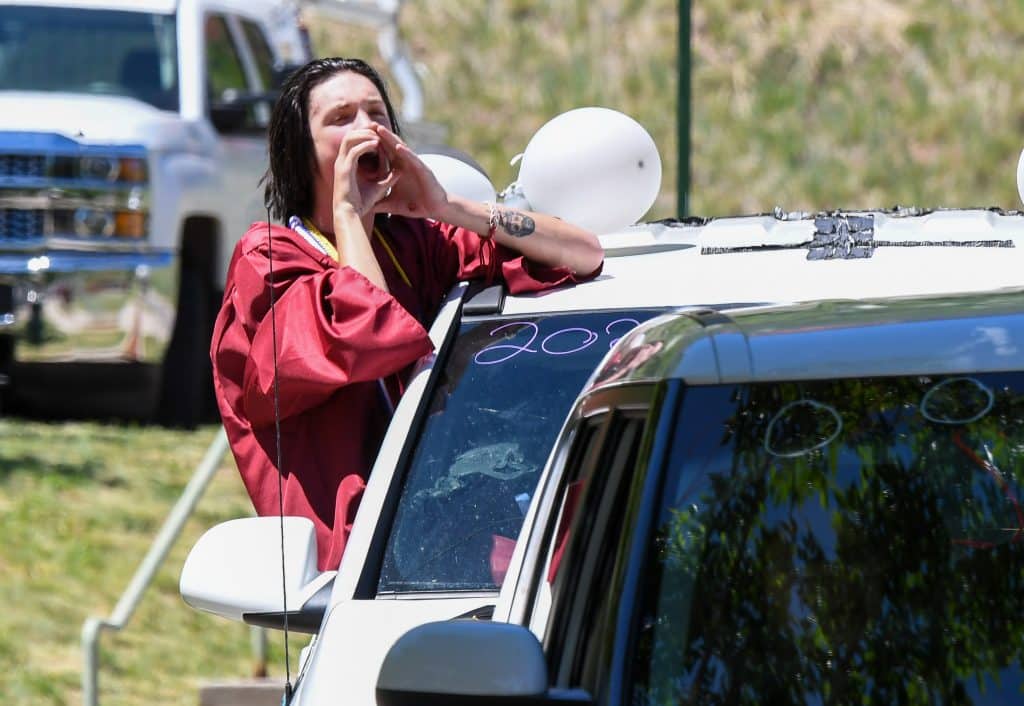 A 2020 Yampah Mountain High School graduate yells in support of a fellow graduate at the drive-in graduation ceremony on Firday morning.