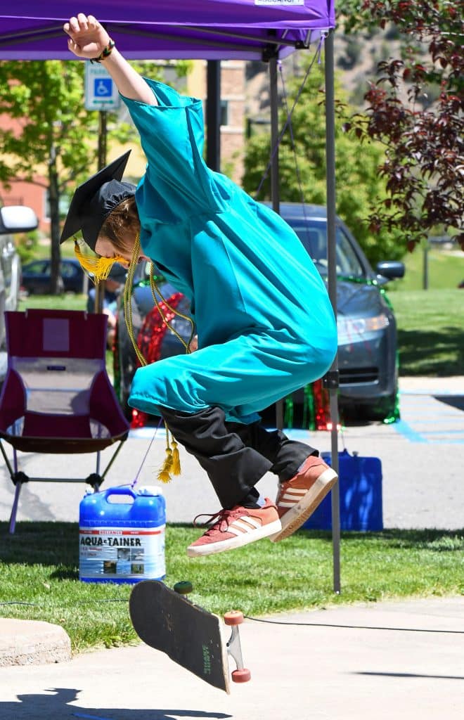 A Yampah Mountain High School graduate performs a trick on his skateboard just before receiving his diploma at the drive-in graduation ceremony on Friday morning.