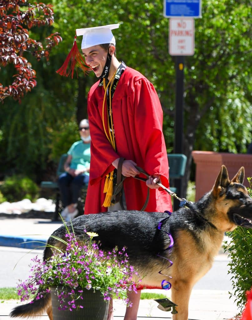 A 2020 Yampah Mountain High School graduate and his dog listen in as his advisor says a few words during the drive-in ceremony on Friday morning.