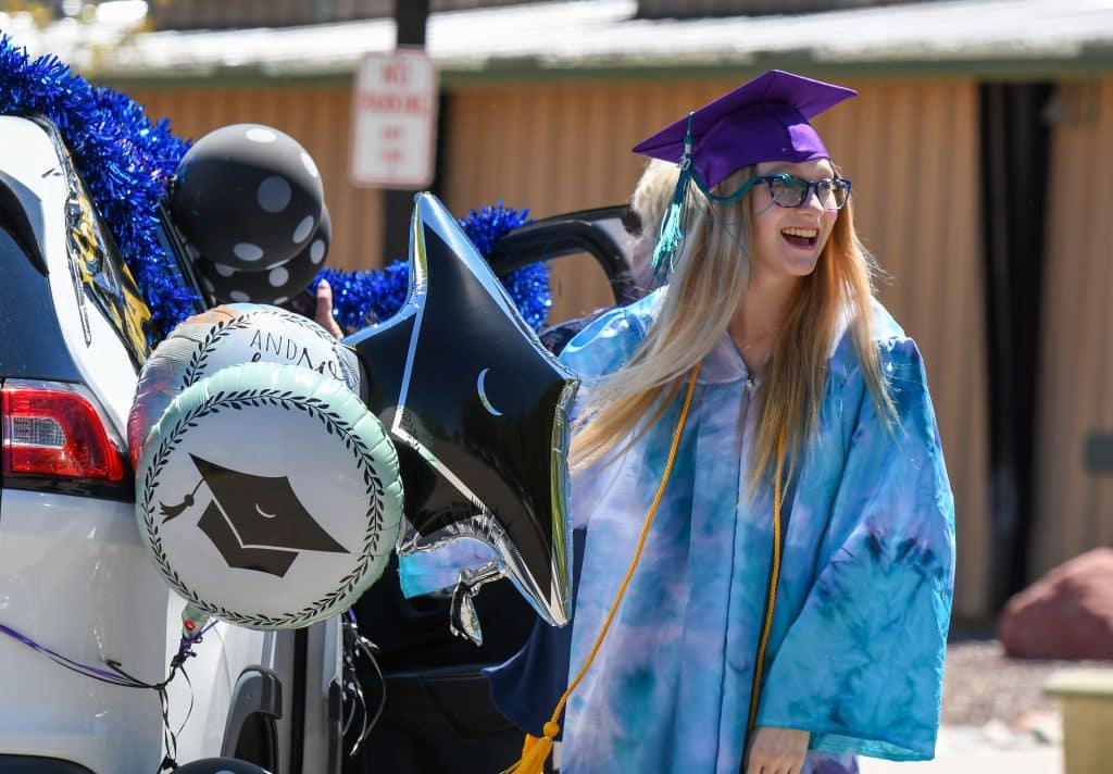 A Yampah Mountain high School graduate reacts to supporters during the drive-in graduation ceremony on Friday morning.