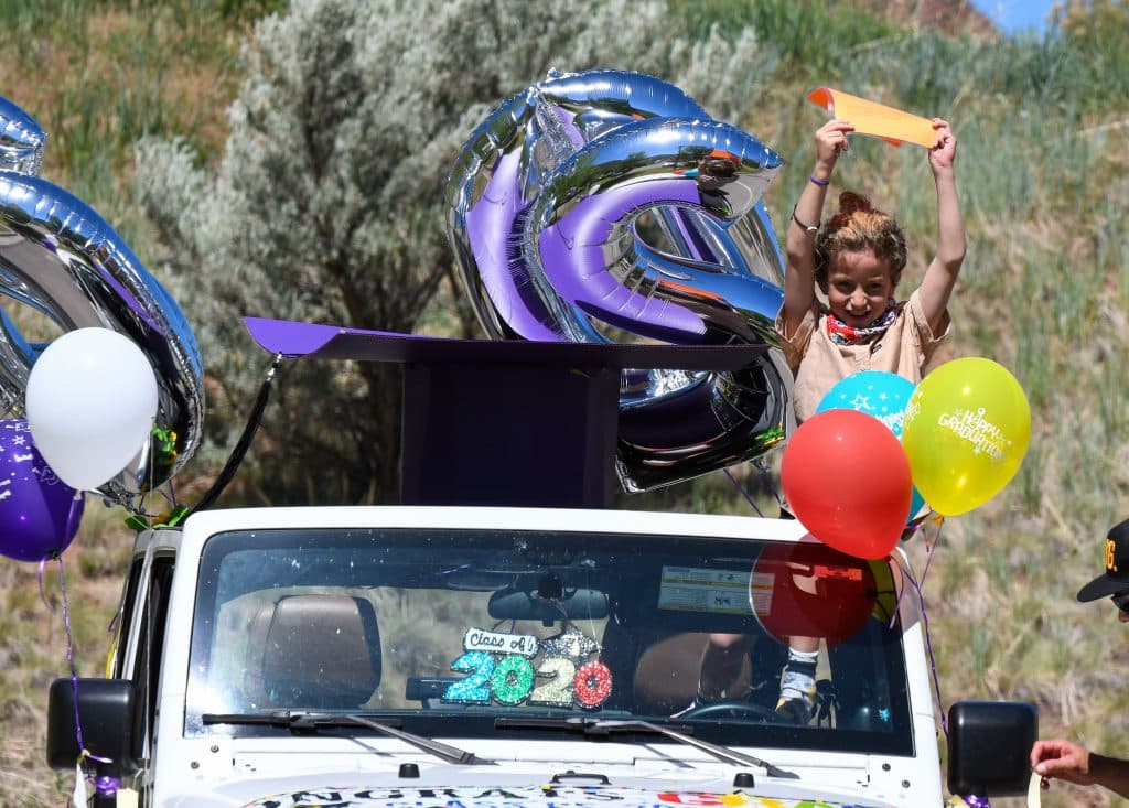 A young supporter cheers for a graduate at the Yampah Mountain High School class of 2020 drive-in graduation ceremony on Friday morning.