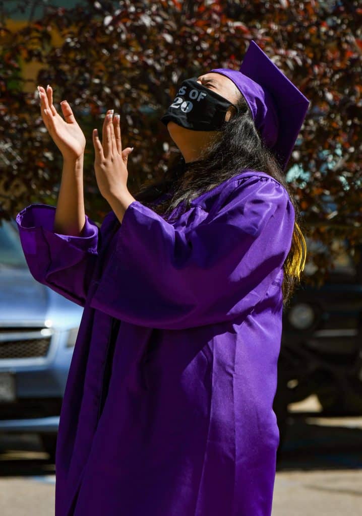 A Yampah Mountain High School graduate laughs during a speech by her advisor before recieving her diploma at the drive-in graduation ceremony on Friday morning.