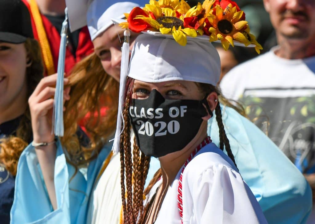A Yampah Mountain High School class of 2020 graduate hangs out with friends before the start of the drive-in graduation ceremony on Friday morning.