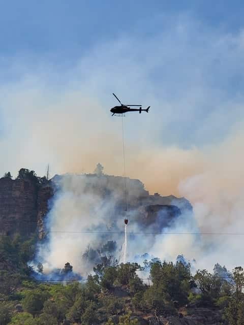 A helicopter makes a water drop on the Grizzly Creek Fire Monday afternoon.