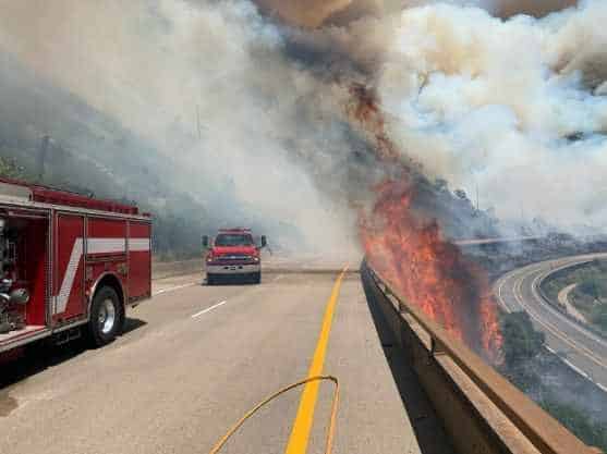 Flames from the Grizzly Creek Fire lick over the westbound lanes of Interstate 70.