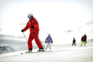 An instructor leads a children's ski lesson at Copper Mountain. The resort's West Village and surrounding terrain is perfect for beginners and young skiers.