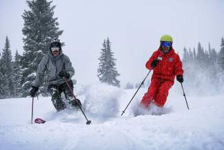 An instructor and student get fresh turns during a powder lesson at Copper Mountain. The resort offers several lessons for advanced and expert students, including advanced instruction for riding deep powder on skis made for backcountry conditions.