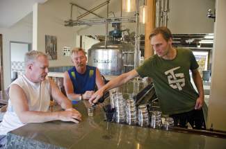 Max Vogelman pours a sample for Rob Hubler and Jim Kelly.