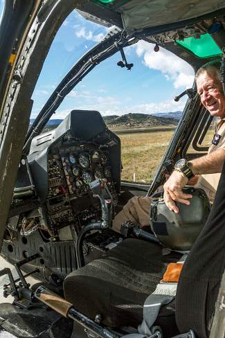 Longtime HAATS helicopter pilot Carl Gray sits in the cockpit of his Bell OH-58 Kiowa helicopter preparing for their final flight Wednesday in Gypsum.