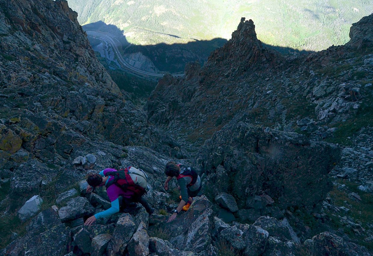 Local hikers Sara Skinner (purple) and Ben Trollinger drop down a rocky chute between Peak Three (12,676 feet) and Peak Four (12,866 feet) during an attempt of the Tenmile Traverse in August.