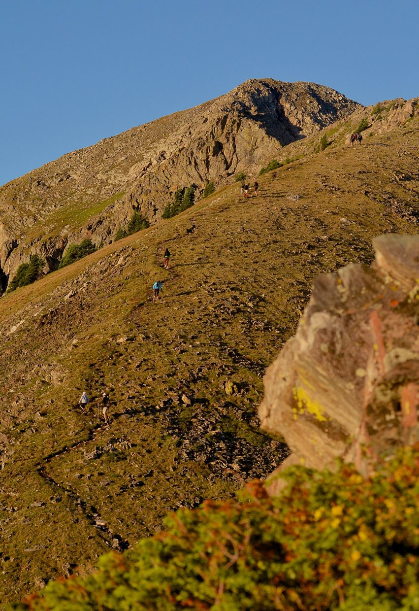 Tiny dots slowly move up a slice of singletrack on the final approach to Peak One (12,805 feet) near Frisco early on an August morning. The first stretch of the Tenmile Traverse follows a well-worn trail from Mount Royal to Peak One before the trail gives way to routefinding with cairns.