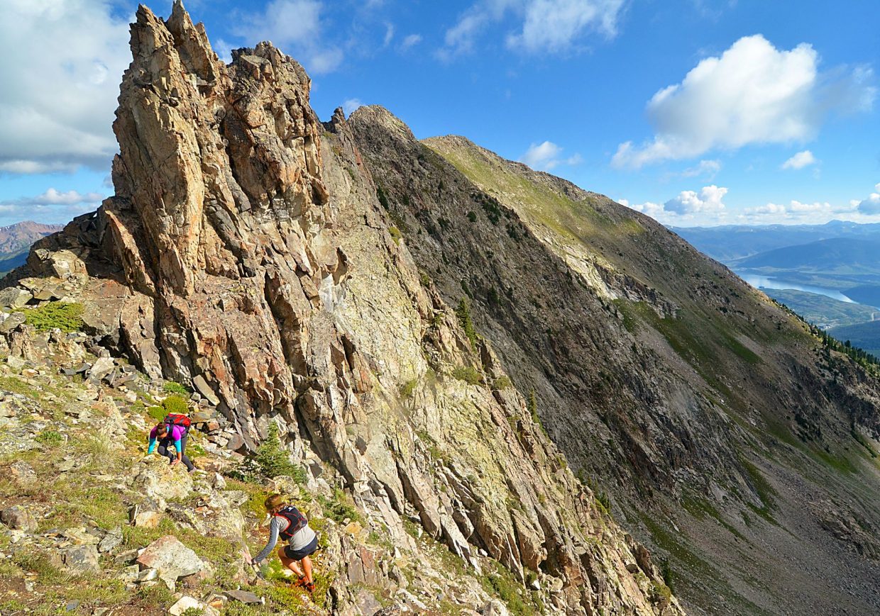 Local hikers Sara Skinner (purple) and Ben Trollinger pass by the Dragon's Teeth formation between Peak Three (12,676 feet) and Peak Four (12,866 feet) during an attempt of the Tenmile Traverse. The first stretch of the traverse is extremely exposed, with a combination of ridgeline scrambling and boulder fields.