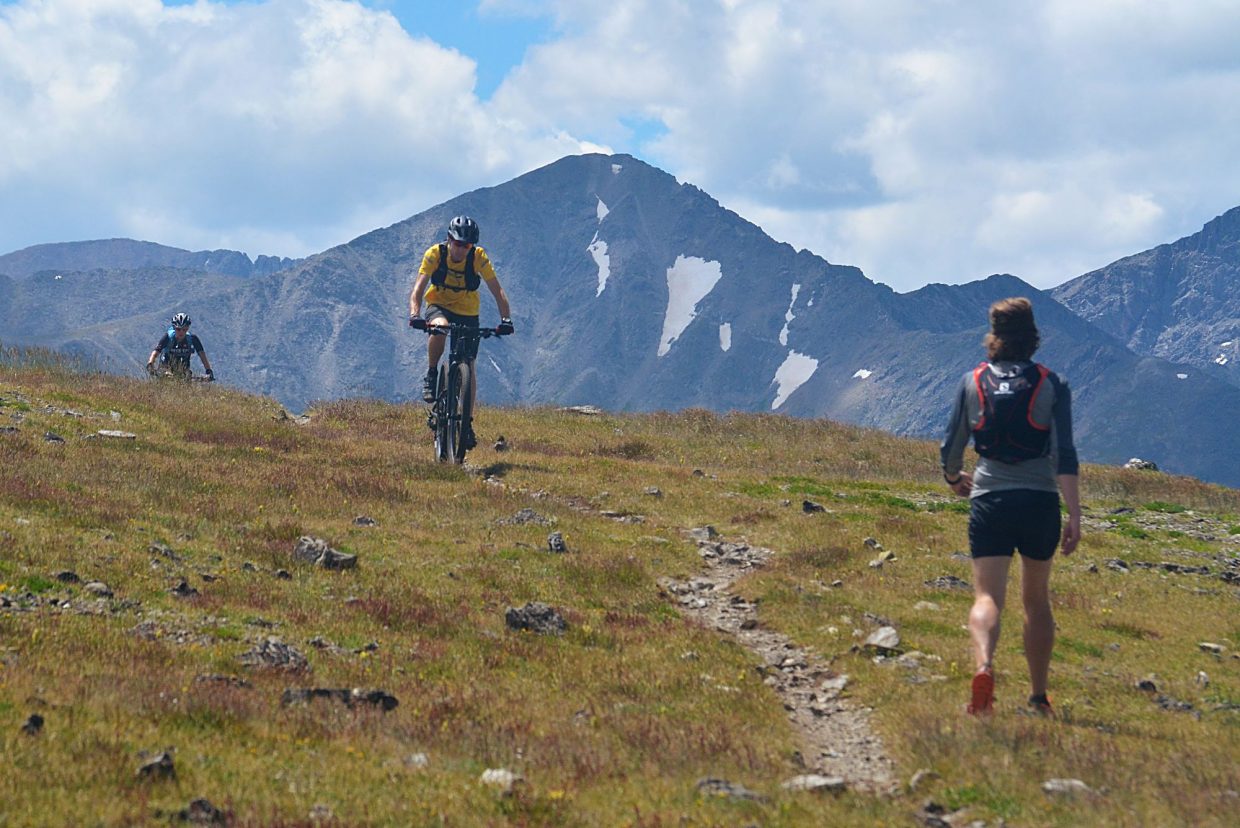 Summit Daily News managing editor Ben Trollinger (right) steps to the side of upper Wheeler Trail on the Tenmile Range as cyclists approach from Wheeler Pass. The Tenmile Traverse meets with occasional stretches of trail after leaving Peak One, but the most common route stays high on the cairn-marked ridgeline.