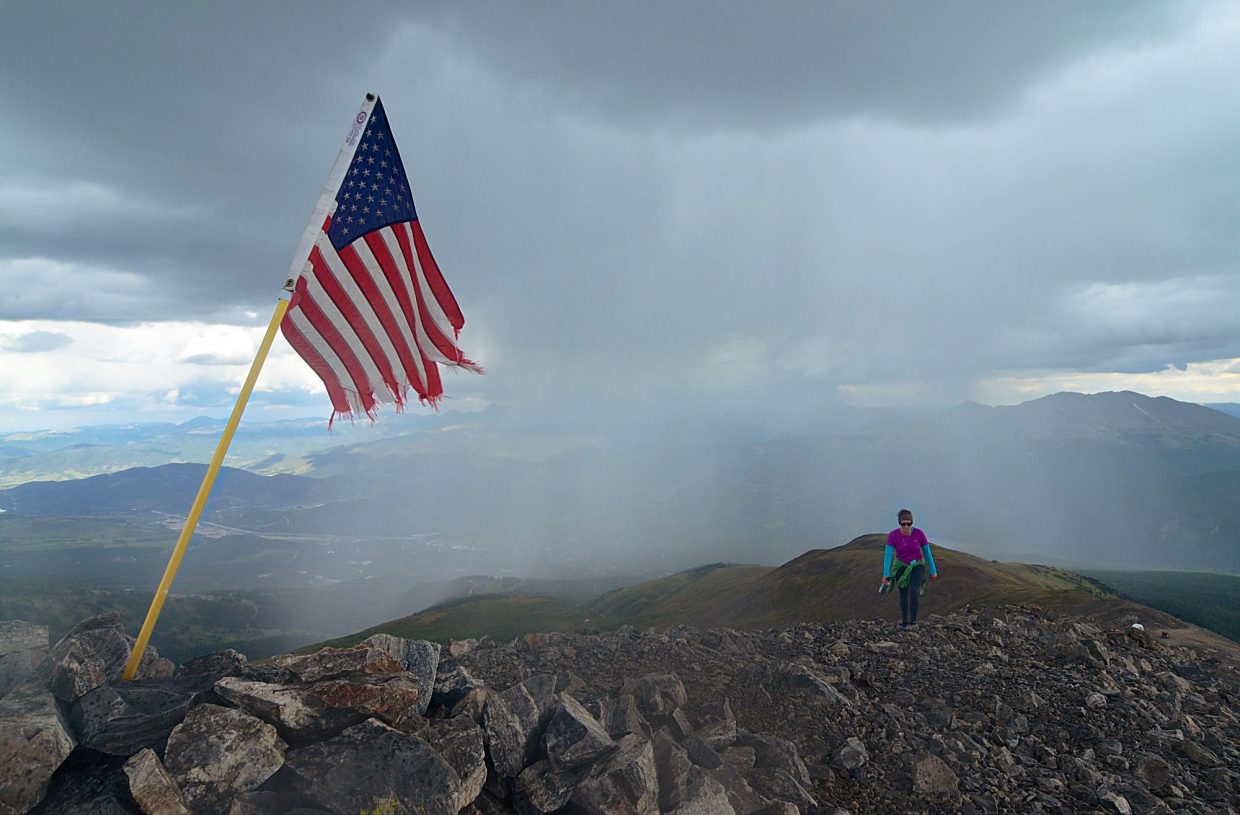 Frisco local Sara Skinner reaches the summit of Peak 10 (13,633 feet) as dark rainclouds form over the valley beneath Peak 9 (13,195 feet) on the final leg of the Tenmile Traverse. Our group completed the 14.5-mile traverse in just under 12 hours.