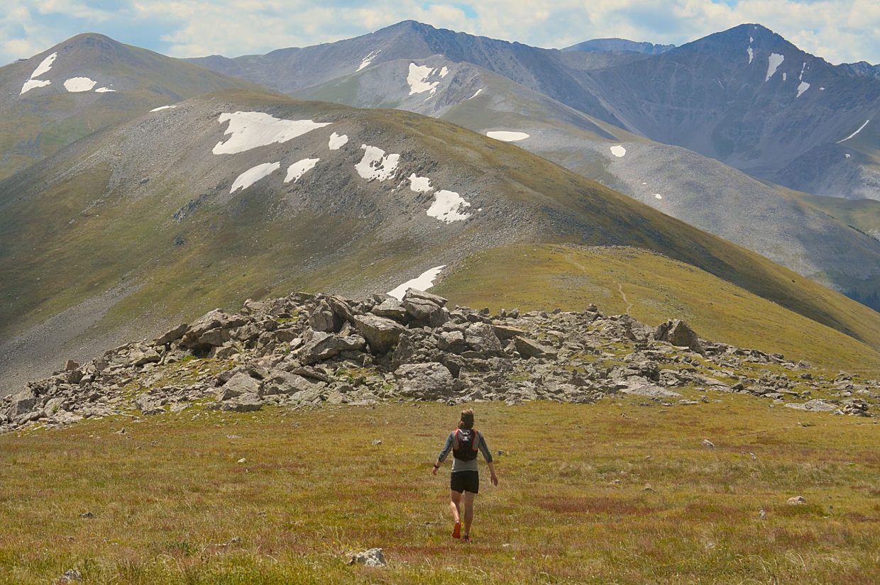Summit Daily News managing editor Ben Trollinger hikes through high-alpine tundra on the Tenmile Range, with the rounded summit of Peak Five (12,855 feet) immediately in the background.