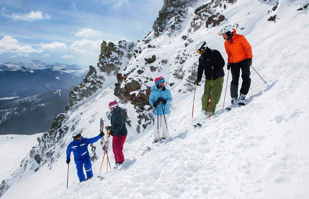 An instructor pauses with a group high above tree line during an adult ski lesson at Breckenridge. The resort's new adult program, Breck Guides, takes students on trips to alpine terrain and hike-to features like chutes.
