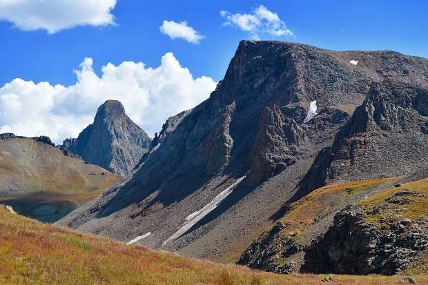 After descending Coxcomb Pass, hikers slowly switch back down, eventually reaching the bottom of Wetterhorn Basin. The peak for which it's named for is the prominent mountain in the distance (on the left).