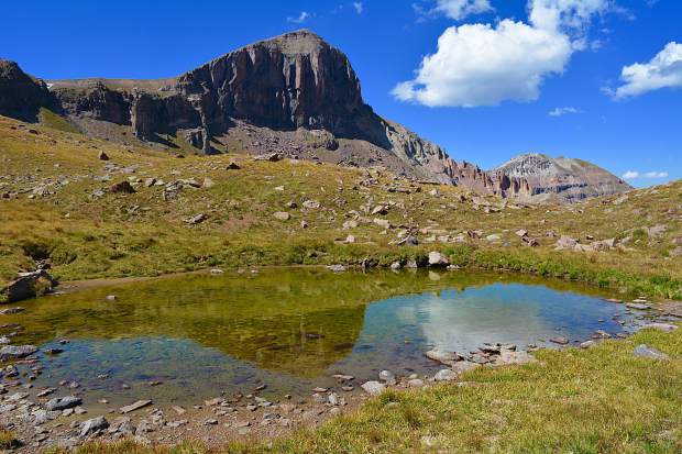 A stunning reflection of an unnamed 13,000 foot mountain in a shallow pool within the Uncompahgre Wilderness area in the San Juan mountain Range.