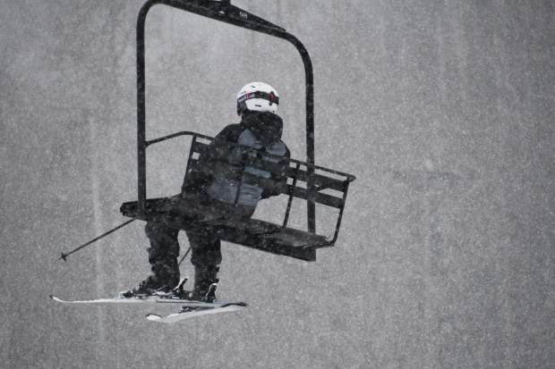 A lone skier takes the lift up the mountain during the opening day at Sunlight Mountain.