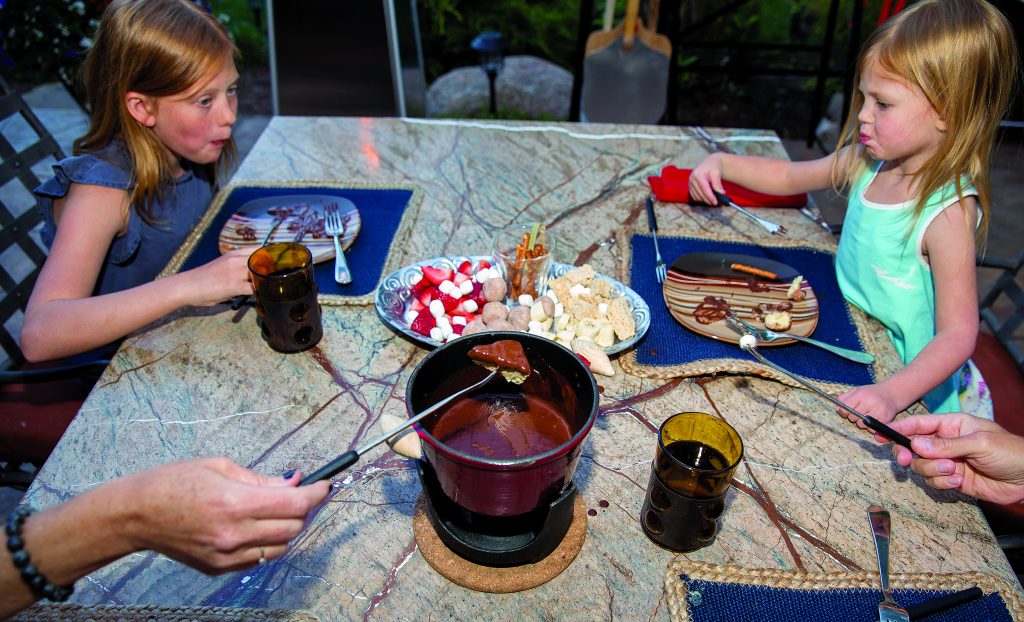 
Zoe Larese, 11, and Valen Larese, 3, enjoy the Fondue at Home dessert which includes a pot of melted Belgium chocolate along with a selection of sweet treat to dip in the pot, like fresh strawberries, rice crispy treats and marshmellows.