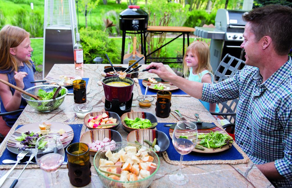 Fondue at Home provides the perfect summer outdoor dining experience a fully catered fondue meal at home. The meal includes a melted cheese pot and a hot pot of beef broth that stays warm as the evening cools down along with plenty of meat, bread and vegetable options to dip in the fondue and a fresh salad and a dessert fondue pot.