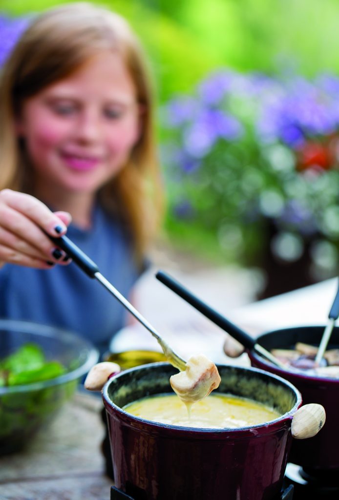Zoe Larese, 11, goes traditional on her fondue dip with bread and hot melted cheese.