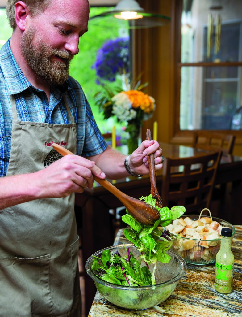 Derek George, owner of Fondue at Home, tosses salad as part of the Fondue at Home experience.